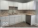 Bright kitchen equipped with white cabinets, stainless steel appliances, and brick backsplash at 6642 E 47Th St, Indianapolis, IN 46226