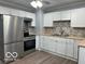 Well-lit kitchen with modern appliances, white cabinets, and stainless steel refrigerator at 6642 E 47Th St, Indianapolis, IN 46226