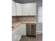 Cozy kitchen featuring white cabinetry, stainless steel dishwasher, and light wood countertops at 6642 E 47Th St, Indianapolis, IN 46226