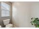 Cozy half bathroom featuring toilet under window and plant in corner at 6681 Keepsake Dr, Whitestown, IN 46075