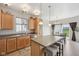 Well-lit kitchen features an island with seating, wood cabinets, stainless steel appliances, and a dining area with access to backyard at 6681 Keepsake Dr, Whitestown, IN 46075