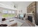 Cozy living room featuring a brick fireplace, large windows, and a comfortable seating area at 6681 Keepsake Dr, Whitestown, IN 46075