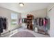Large walk-in closet with hanging rods and rolling racks for easy clothing storage at 6681 Keepsake Dr, Whitestown, IN 46075