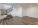 Finished basement area with wood-look floors, a staircase, and white walls ready for customization at 6953 Equality Blvd, Carmel, IN 46033