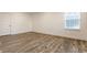 Bedroom featuring wood-look flooring, a bright window, and a door leading to a closet or bathroom at 6953 Equality Blvd, Carmel, IN 46033