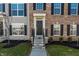 Inviting front entry with a black door, white trim, and a well-kept lawn with shrubbery at 6953 Equality Blvd, Carmel, IN 46033