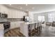 Spacious open kitchen featuring white cabinets, stainless steel appliances, a large island, and seating at 6953 Equality Blvd, Carmel, IN 46033