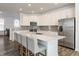 Modern kitchen with stainless steel appliances, a large island with seating, and bright white cabinets at 6953 Equality Blvd, Carmel, IN 46033
