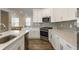 Bright, open kitchen with stainless steel appliances, white cabinetry, and a large island with seating at 6953 Equality Blvd, Carmel, IN 46033