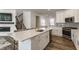 Open-concept kitchen features a large island, stainless steel appliances, and a view to the fireplace and stairs at 6953 Equality Blvd, Carmel, IN 46033