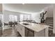 Large kitchen island with stainless dishwasher and sink overlooks living and dining spaces and staircase at 6953 Equality Blvd, Carmel, IN 46033