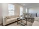 A sun-lit, bright living room features elegant sofas, hardwood floors, and a decorative glass table at 6953 Equality Blvd, Carmel, IN 46033