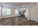 Open-concept living room with wood-look floors, bright windows, and staircase leading to the upper level at 6953 Equality Blvd, Carmel, IN 46033