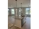 Kitchen island with stainless sink, granite countertop, and pendant lighting, overlooking the living area at 799 Rose Garden Way, Westfield, IN 46074