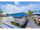A covered boat sits in the water attached to the docks with boardwalk access on a sunny day at 8158 Shorewalk Dr # F, Indianapolis, IN 46236