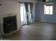 Cozy living room with fireplace, plank flooring, and access to outdoor patio at 8158 Shorewalk Dr # F, Indianapolis, IN 46236