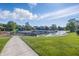 A picturesque view of waterfront property features a walkway along the grassy lawn at 8158 Shorewalk Dr # F, Indianapolis, IN 46236