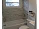 Cozy bathroom featuring tiled wall, bathtub with shower, and a toilet with a modern sink at 838 Highland Dr, Whiteland, IN 46184