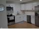 Well-lit kitchen with white cabinets, stainless appliances, and wood-look flooring at 838 Highland Dr, Whiteland, IN 46184