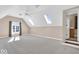 Large bonus room featuring multiple skylights and adjacent bathroom at 8717 Vintner Ct, Indianapolis, IN 46256