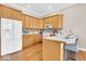 Well-lit kitchen featuring wooden cabinets, hardwood floors and a white countertop with bar stool seating at 8717 Vintner Ct, Indianapolis, IN 46256