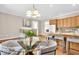 Bright kitchen area with wooden cabinets and an adjacent dining room area featuring a glass table at 8717 Vintner Ct, Indianapolis, IN 46256