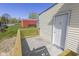 Side entry back porch with white door and a red shed in the background at 8745 Big Bend Rd, Martinsville, IN 46151