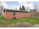 Expansive backyard showcasing a brick exterior with multiple windows and a well-maintained lawn at 89 E Walnut St, Fountaintown, IN 46130