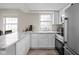 Kitchen with white cabinets, stainless appliances, and marble countertops at 89 E Walnut St, Fountaintown, IN 46130