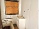 Bathroom with older fixtures, boarded-up window, and cosmetic damage at 918 N Dearborn St, Indianapolis, IN 46201