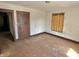Spacious bedroom featuring hardwood floors, original wood trim, and natural light from a boarded up window at 918 N Dearborn St, Indianapolis, IN 46201