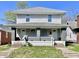 Two-story duplex with gray siding, covered front porches, and steps leading to separate entrances at 918 N Dearborn St, Indianapolis, IN 46201