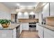 Well-lit kitchen featuring stainless steel appliances, granite countertops, and ample cabinet space at 958 Tamarack Cir N Dr, Indianapolis, IN 46260