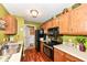 Charming kitchen with wood cabinets, black appliances, and direct access to the laundry area for added convenience at 963 Wickham Ct # 103, Carmel, IN 46032