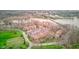 An aerial view shows apartment buildings, parking lots, garages, green space, and a waterway at 102 Knoll Ct # D, Noblesville, IN 46062