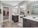 Bright bathroom featuring double sinks, dark wood cabinets, walk-in closet and doorway to bedroom at 1075 Barberry Dr, Greenwood, IN 46143
