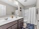 Well-lit bathroom featuring double sinks, modern fixtures, and a shower with a white shower curtain at 1075 Barberry Dr, Greenwood, IN 46143