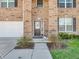 Inviting front entrance with a brown door, green bushes, and lush green lawn at 1075 Barberry Dr, Greenwood, IN 46143