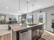 Open floor plan with a kitchen island, stainless steel dishwasher, and view into the bright living room at 1075 Barberry Dr, Greenwood, IN 46143