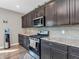 Kitchen featuring dark cabinetry, a stainless steel oven, granite countertops, and a stylish subway tile backsplash at 1075 Barberry Dr, Greenwood, IN 46143