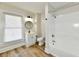 A pristine bathroom with white fixtures, wood-look flooring, and natural light streaming through the window at 1145 N Belleview Pl, Indianapolis, IN 46222