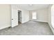 Empty bedroom with gray carpet, natural light streaming through the window, and an adjacent room at 1145 N Belleview Pl, Indianapolis, IN 46222