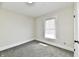 Empty bedroom with neutral walls, plush carpet, a window with blinds, and a closet door at 1145 N Belleview Pl, Indianapolis, IN 46222