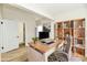 Virtual staging for a home office with a wood desk and a bookshelf at 1145 N Belleview Pl, Indianapolis, IN 46222
