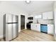 A kitchen with stainless steel appliances, white cabinets, and a blue dishwasher at 1145 N Belleview Pl, Indianapolis, IN 46222