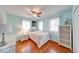 Light filled bedroom with wood floors, ceiling fan, white closet, and a double-hung window at 115 King Arthur Dr, Franklin, IN 46131