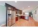 Spacious kitchen with stainless steel refrigerator, dark wood cabinets, and seamless flow to the living area at 115 King Arthur Dr, Franklin, IN 46131