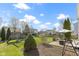 Large backyard with mature trees and playset visible from the paved patio at 11741 Langham Crescent Ct, Fishers, IN 46037