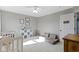 Neutral bedroom features a white crib, gray sofa and neutral-colored decor at 11741 Langham Crescent Ct, Fishers, IN 46037