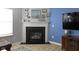 Fireplace with decorative mantel, next to a blue accent wall, creating a cozy focal point in the living area at 11741 Langham Crescent Ct, Fishers, IN 46037